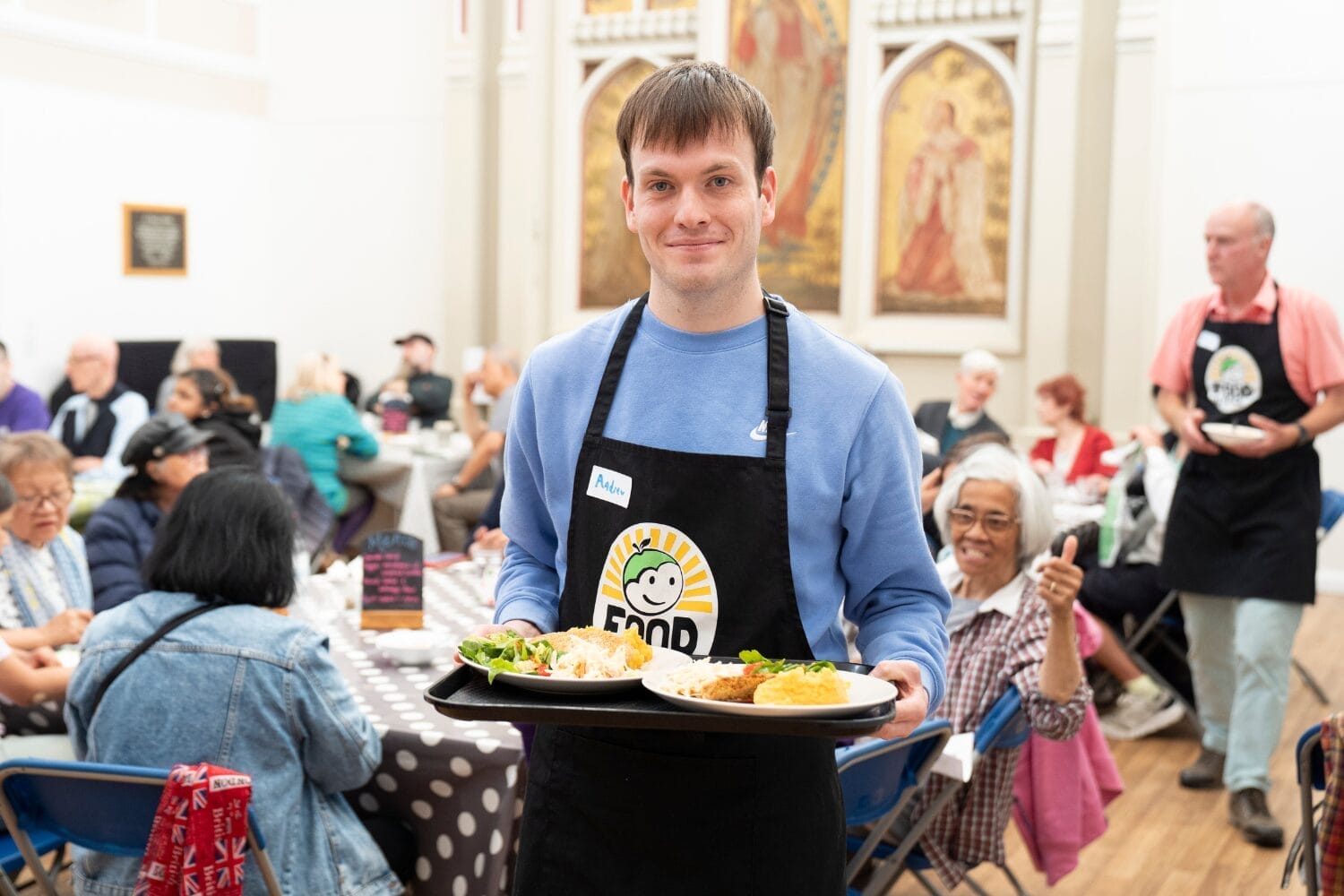 Volunteer serving food at FoodCycle community meal