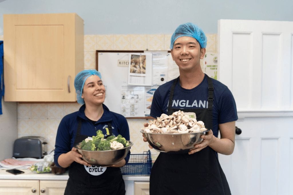 two people holding bowls of food and smiling