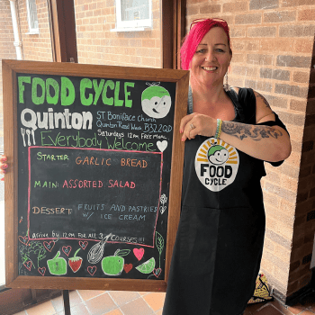 Photo of volunteer Bev, with menu board