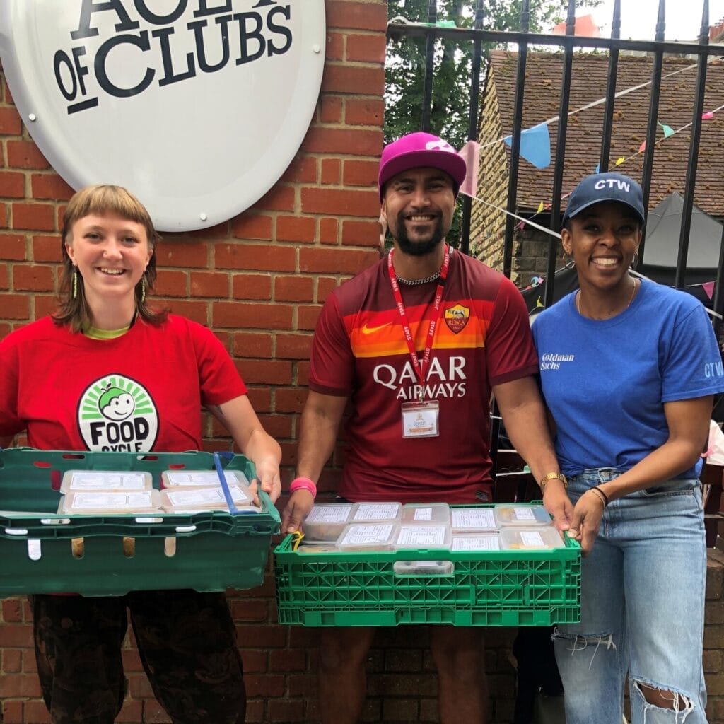 FoodCycle and Ace of Clubs staff members, holding crates of meals.