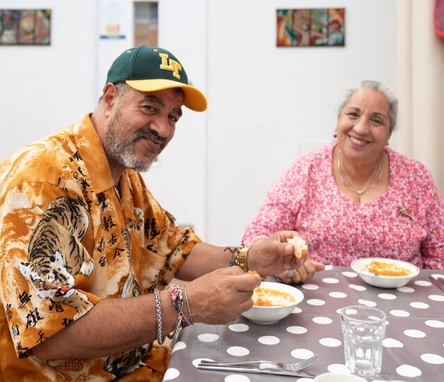 Two FoodCycle guests at a community meal eating together
